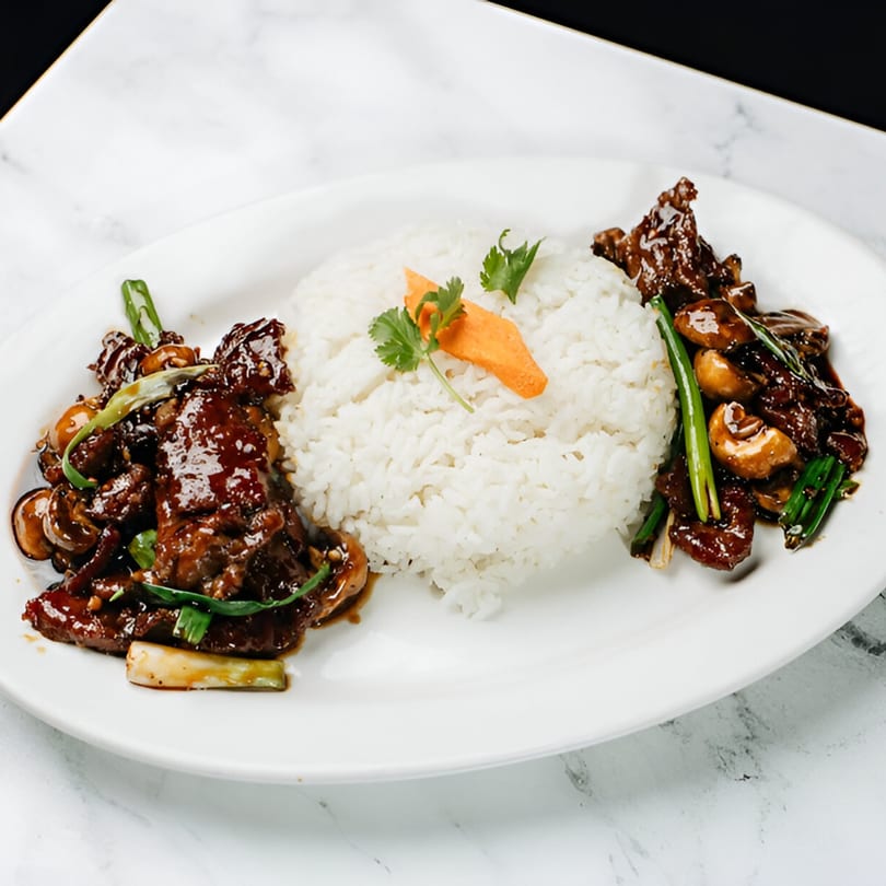 Vinsar's Lounge Asian-fusion beef and mushroom dish with white rice, garnished with carrot and cilantro.